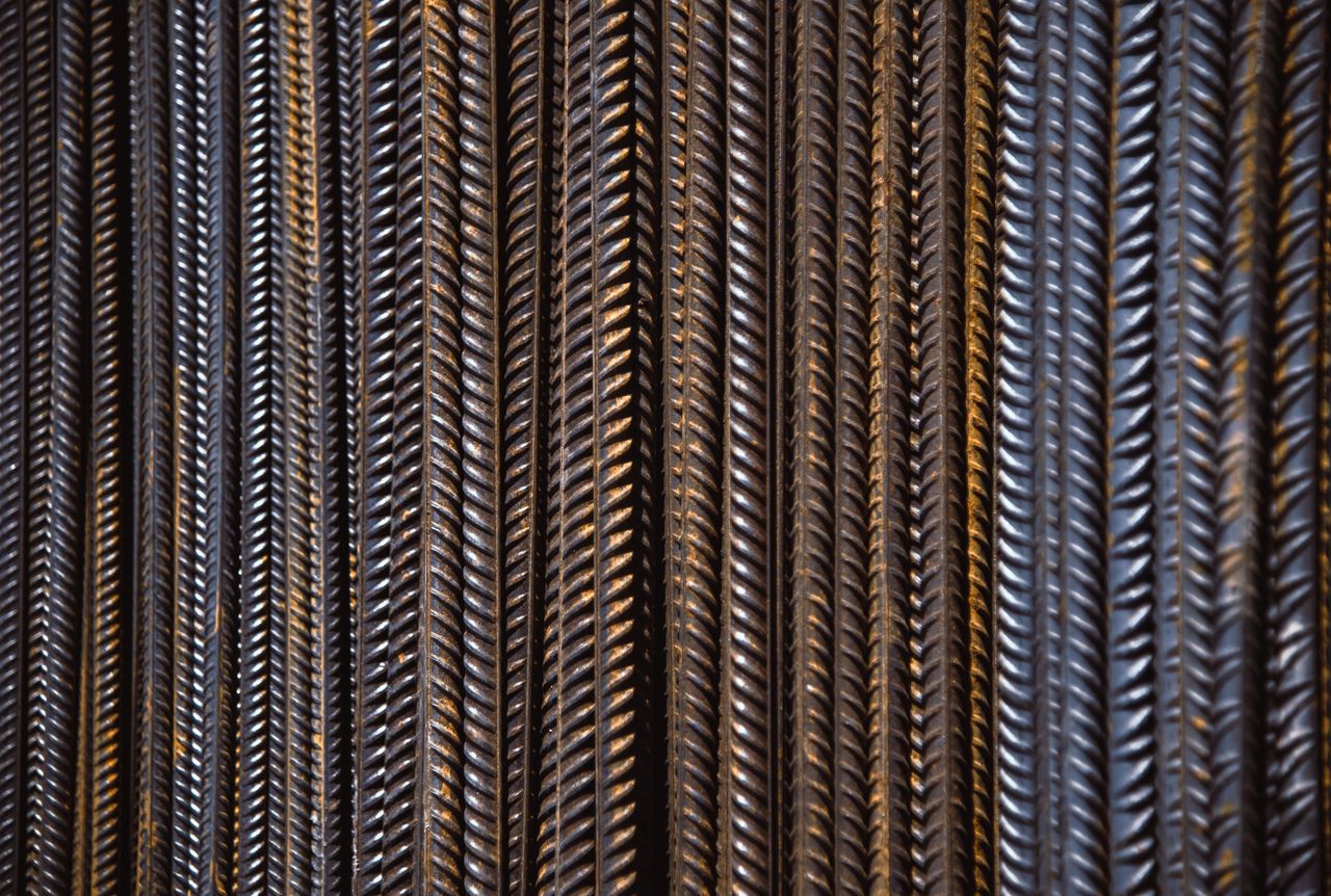 get-in-touch Detailed view of vertically aligned textured rebar showing intricate patterns.